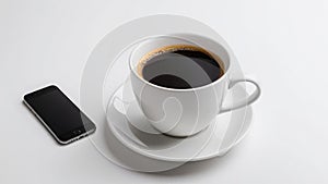 White coffee cup with smartphone on table, modern work setting