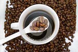 White coffee cup, spoon and roasted coffee beans that isolated on white background. top view