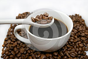 White coffee cup, spoon and roasted coffee beans that isolated on white background. top view