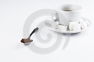 White coffee cup with sugar cubes and metal spoon isolated on white background.Copy space