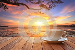 White coffee cup on wood table and view of sunset or sunrise background