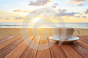 White coffee cup on wood table and view of sunset or sunrise background