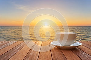 White coffee cup on wood table and view of sunset or sunrise background