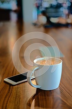 White coffee cup on wooden table on coffee shop