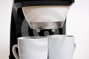 White coffee maker with two mugs on white background