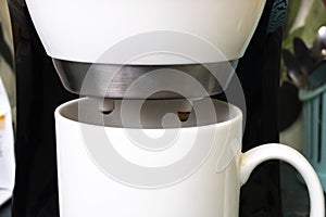 White coffee maker with two mugs on white background