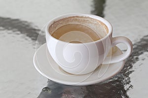 White coffee mug with coffee stains on table.