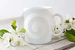 White coffee mug mockup with apple blossom photo