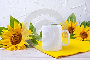 White coffee mug mockup with yellow sunflowers and napkin