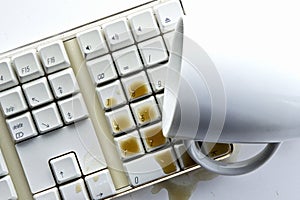 Coffee spilling over computer keyboard