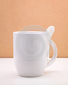 White coffee mug and spoon on backdrops. Ceramic tea cup for your design