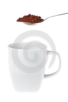 White coffee mug with a teaspoon of instant coffee