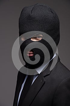 White collar crime. Portrait of businessman in black balaclava l