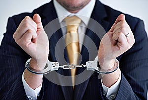 White collar crimes - you will be caught out. a businessman in cuffs.