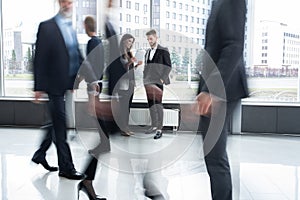 White collar workers going down office corridor during working day.