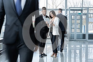 White collar workers going down office corridor during working day.
