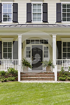 White colonial house, porch and plants