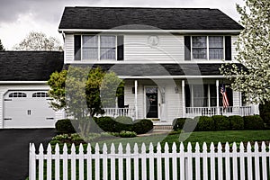White colonial house with white picket fence
