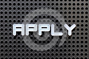 White alphabet with word apply on black pegboard background