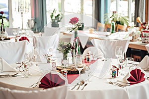 White color arrangement festive table decoration. Red rose flower in decorated high glass vase and arrangement of