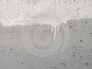 White color on grey color rough texture concrete wall skin with random small hole pattern cement plaster on its surface