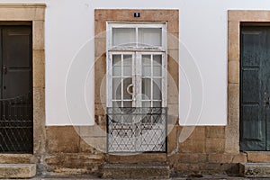 A white color old styled wooden door in Torre de Moncorvo streets in Portugal photo