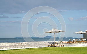 White color recliner beach seating with white parasol facing the