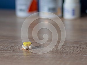 white and colored pills lie on a wooden table against the background of jars with medicines health day. doctors and medicine