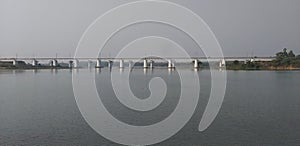 A white colored rail way bridge is constructed over a river.