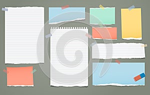 White and colorful lined torn note, notebook paper pieces for text stuck with sticky tape on green background. Vector