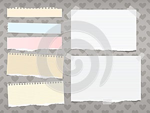 White and colorful ripped ruled, striped note, copybook, notebook paper stuck on background created of hearts shape.