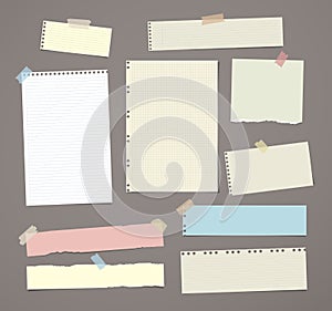 White and colorful striped note paper, copybook, notebook sheet stuck with adhesive tape on dark brown background.