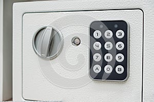 White compact safe with key and combination lock. Deposit module for storing money and documents at home and in the office