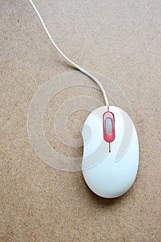 White computer mouse on wooden background.