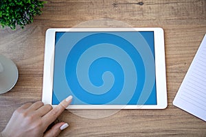 white computer tablet with blue screen and female hand