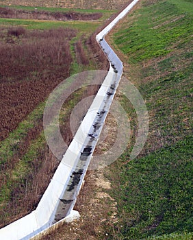 white concrete ditch on the field to transport water for irrigation