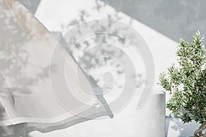 White concrete empty table, organic curtain and olive tree shadow on cement wall. Summer exterior scene for product placement