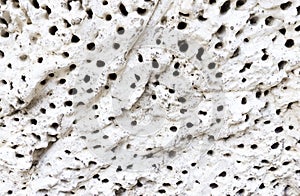 White Concrete Rock Wall with Deep Black Holes on Background
