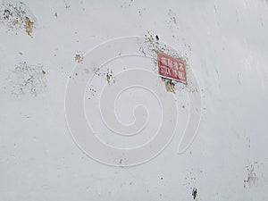 White concrete wall with red stick no bill post sign