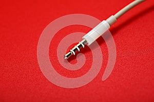 White connector AUX white cable on a red background