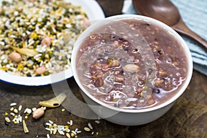 White container holding raw materials of eight treasures porridge on a wooden board