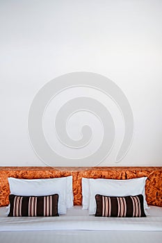 White contemporary hotel style bedroom with white linen high ceilling and striped pattern pillows