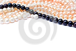 White, coral pink, black pearls on a white background with space for text. Top view, flat lay