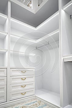 White corner wardrobe section with shelves in walk-in closet