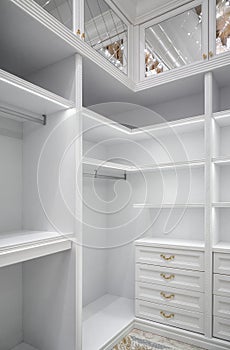 White corner wardrobe section with shelves in walk-in closet