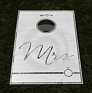 White cornhole game with Mrs written in black text