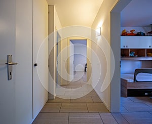 White corridor with built-in closets and open doors