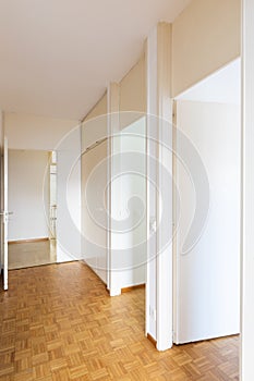 White corridor with parquet and open doors