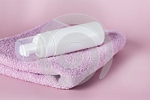 White cosmetics container mockup with towels on Pink background Horizontal Copy Space