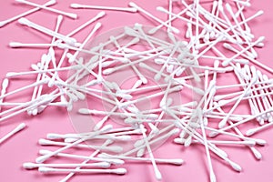 White cotton ear buds on a pink background